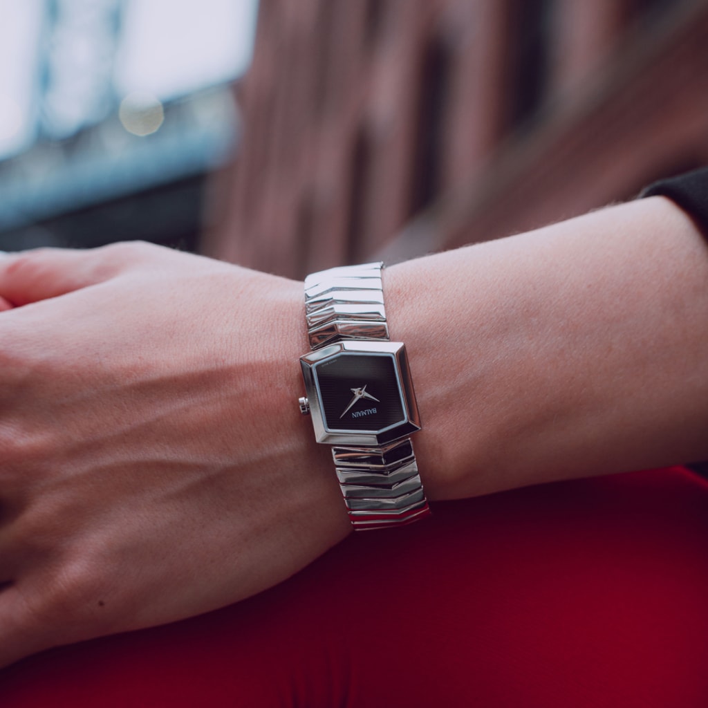 Lifestyle wrist shot of the Balmain Taffetas watch, showcasing its silver tones and elegant sporty design on a woman’s wrist.