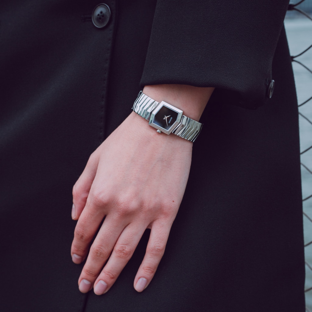 Lifestyle wrist shot of the Balmain Taffetas watch, showcasing its silver tones and elegant sporty design on a woman’s wrist.