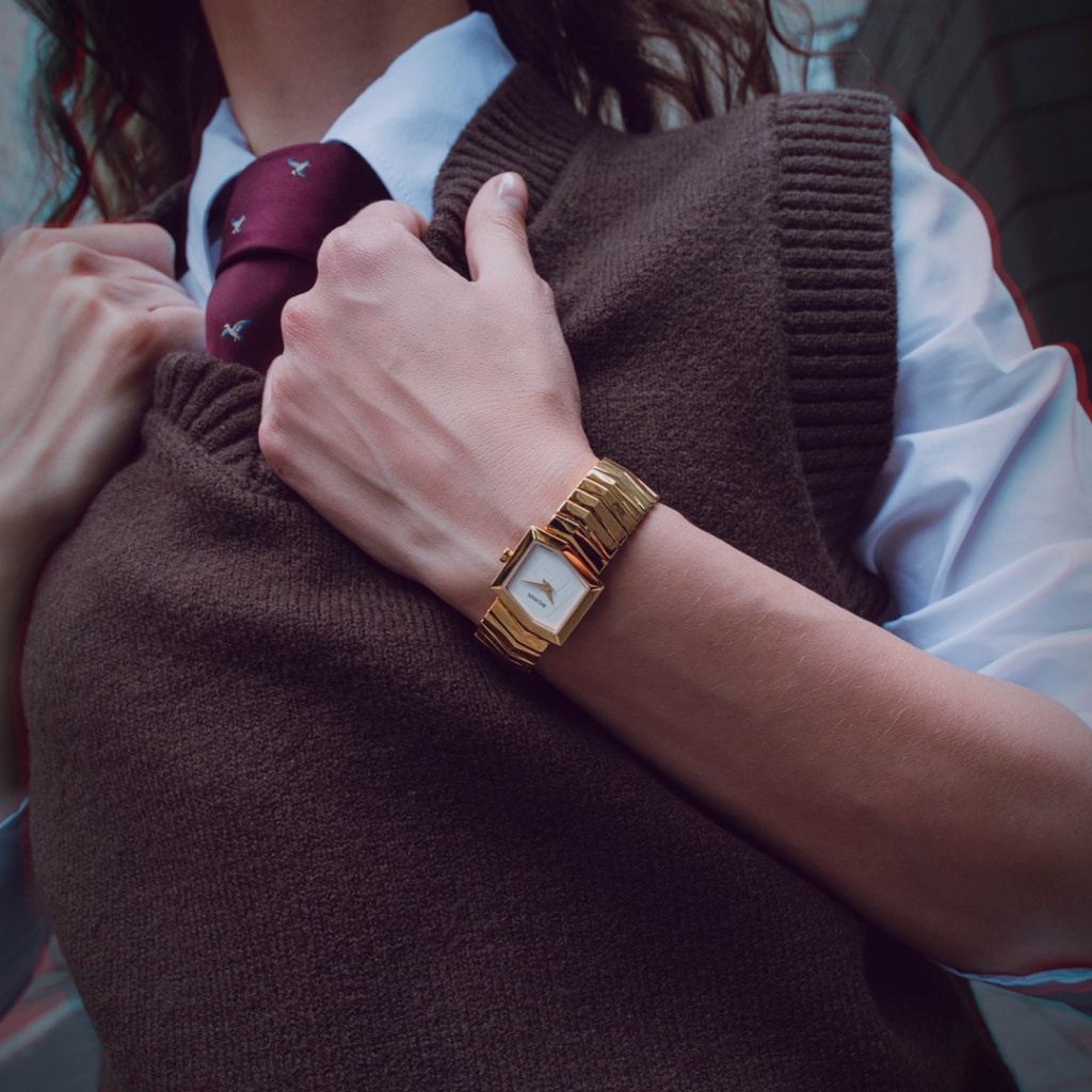 Lifestyle wrist shot of the Balmain Taffetas watch, showcasing its yellow gold PVD tones and elegant sporty design on a woman’s wrist.