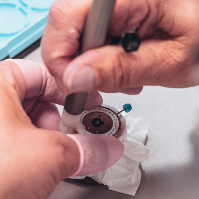 Balmain watch dial showcasing couture-inspired arabesque details and diamonds Detailed view of Swiss watchmaking artistry during Balmain assembly